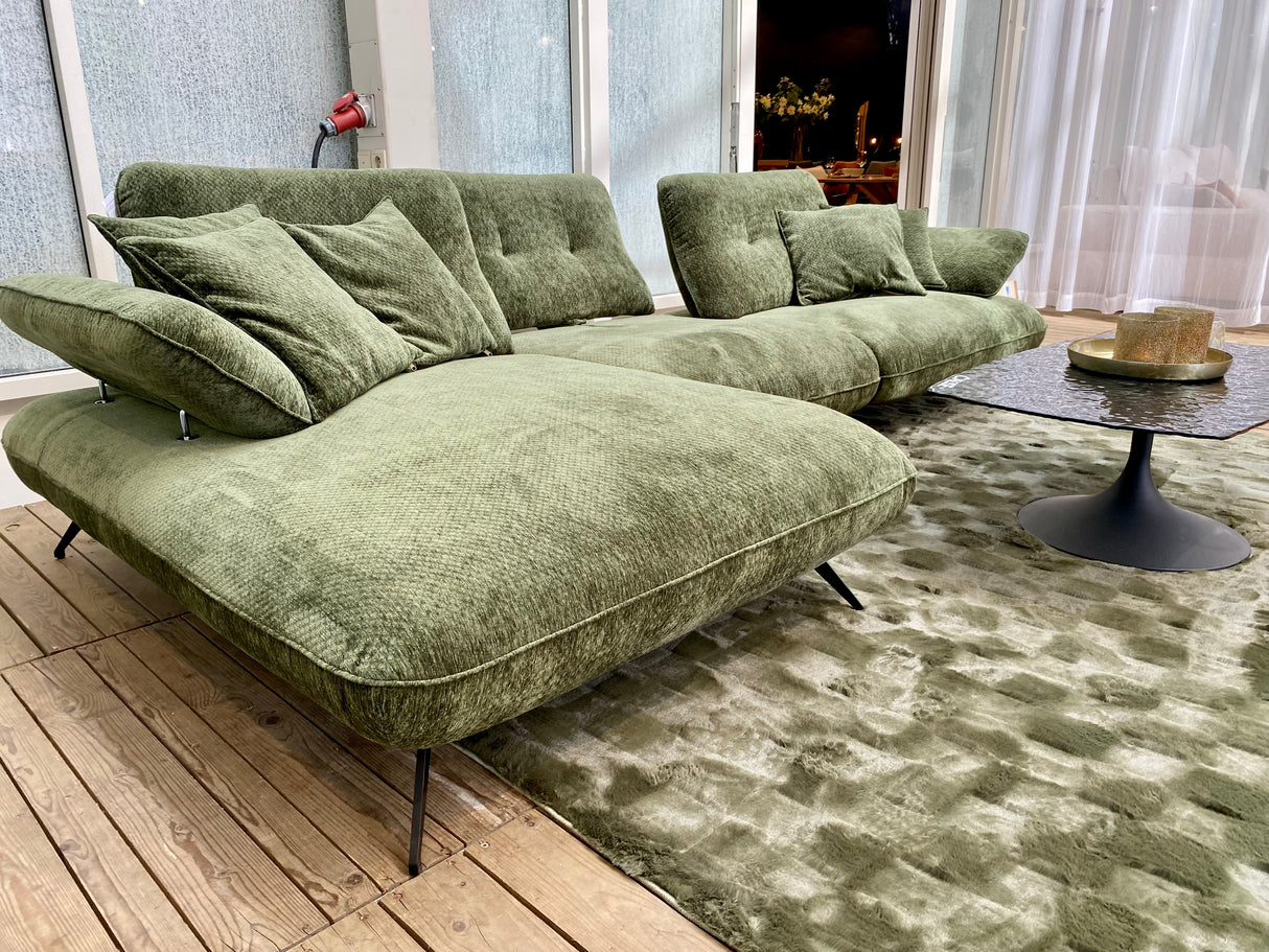 Canapé d'angle méridienne vert avec dossiers avance recule exposé au magasin de meubles à Yerres