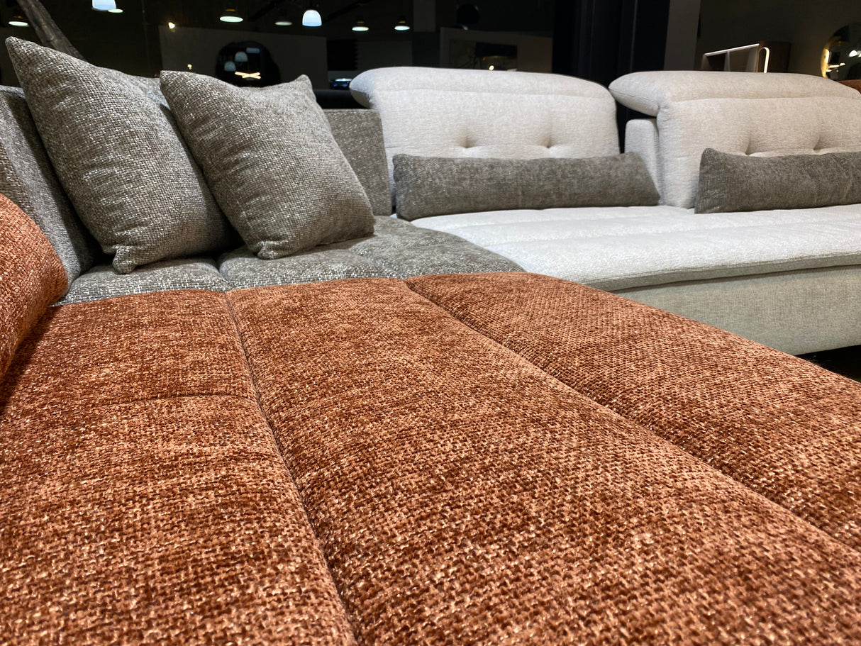 zoom sur le tissu d'un canape panoramique modulable en tissu confortable dossiers avance recule dans un magasin de meuble à Yerres