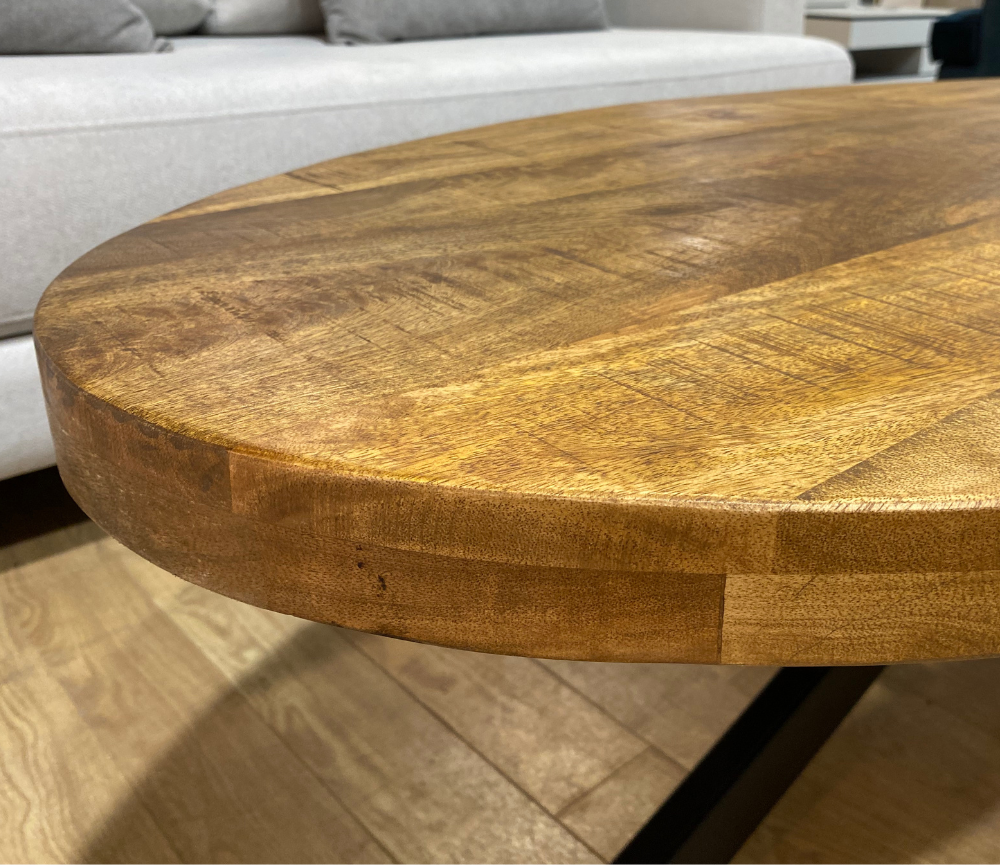 zoom détail plateau d'une table ovale en bois massif pieds métal noir dans le magasin de Yerres