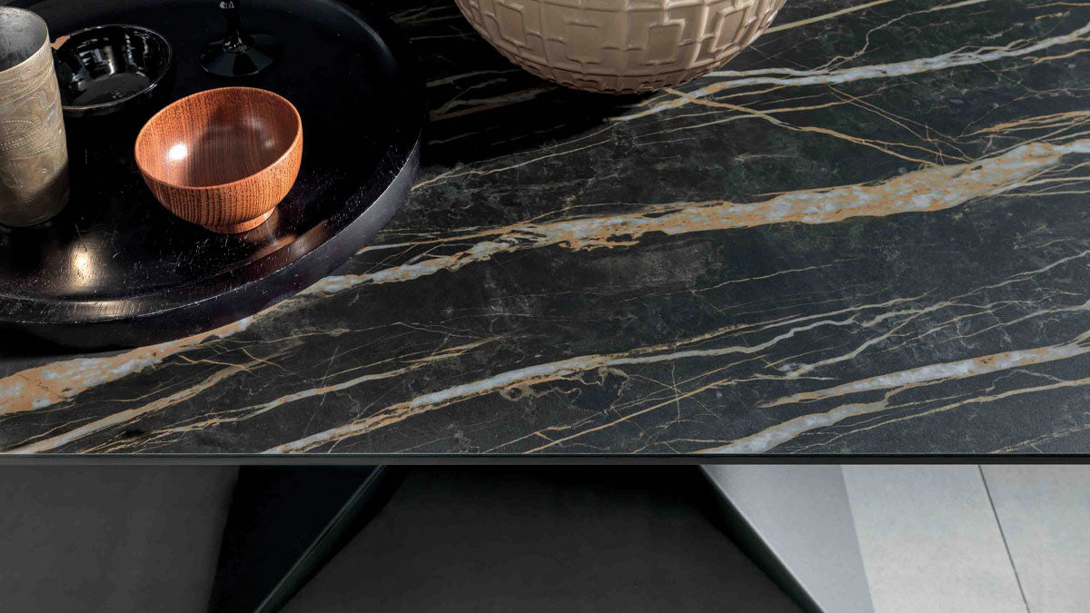 Détail du plateau en céramique effet marbre noir aux veines dorées de la table Sintesi