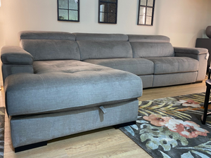 Canapé d'angle Maggy avec méridienne en velours gris dans un salon contemporain avec fenêtres industrielles