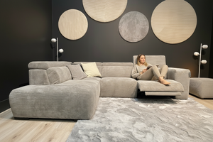 canapé d'angle relax electrique  en tissu velours cotelé avec une femme sur l'assise relax