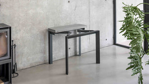 Console Domino en cours d'ouverture, piètement métal pivotant pour former la table