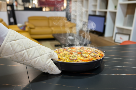 Gros planl d'un plat chaud déposé sur la table en céramique marbre noir