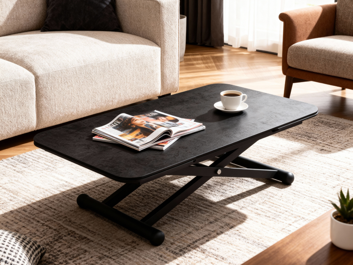 Table basse Enora en céramique anthracite en position basse avec magazines et café dans un salon moderne chaleureux