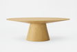 Table ovale en bois chêne clair avec pied central sur fond blanc
