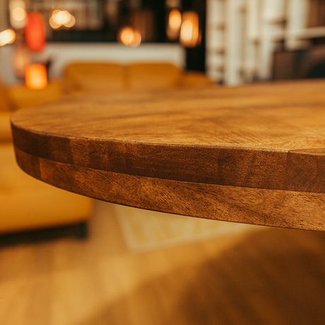 Zoome sur le plateau d'une table ovale en bois massif pieds central métal noir dans le magasin de Yerres